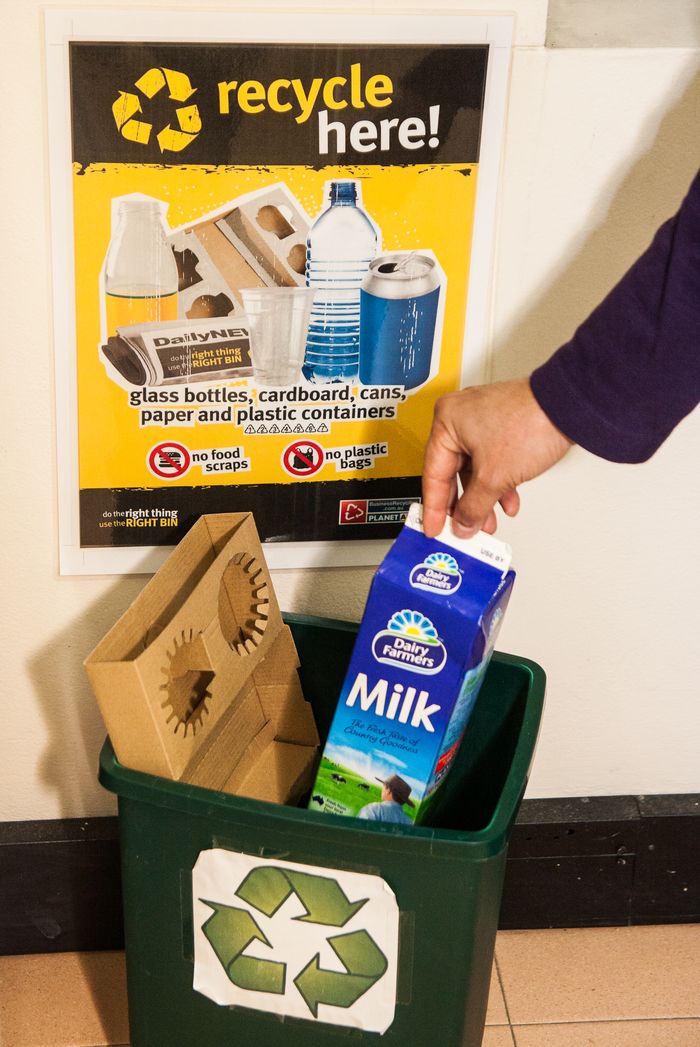 Milk carton being recycled in bin close up - Business Recycling Media
